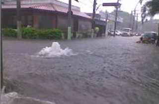 Durante forte aguaceiro, o encontro das águas da Av. dos Bandeirantes e da Rua Alvorada.